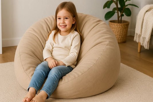 Young girl smiling while sitting comfortably on a beige bean bag chair in a cozy, child-friendly room with soft lighting and warm decor.